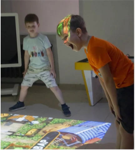 Crianças a jogar no iFloor numa sala de aula.